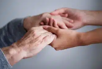 Personne âgée donnant ses mains à une autre personne plus jeune