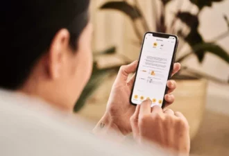 Personne qui est en train de regarder, sur son canapé, son téléphone