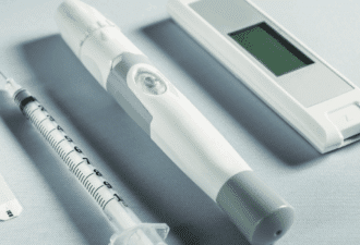 Gros plan sur un dispositif médical connecté — stylo injecteur, seringue et capteur numérique — illustrant les exigences de conformité et de certification des dispositifs médicaux intégrant l’intelligence artificielle en 2025.