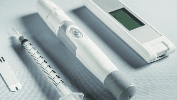 Gros plan sur un dispositif médical connecté — stylo injecteur, seringue et capteur numérique — illustrant les exigences de conformité et de certification des dispositifs médicaux intégrant l’intelligence artificielle en 2025.