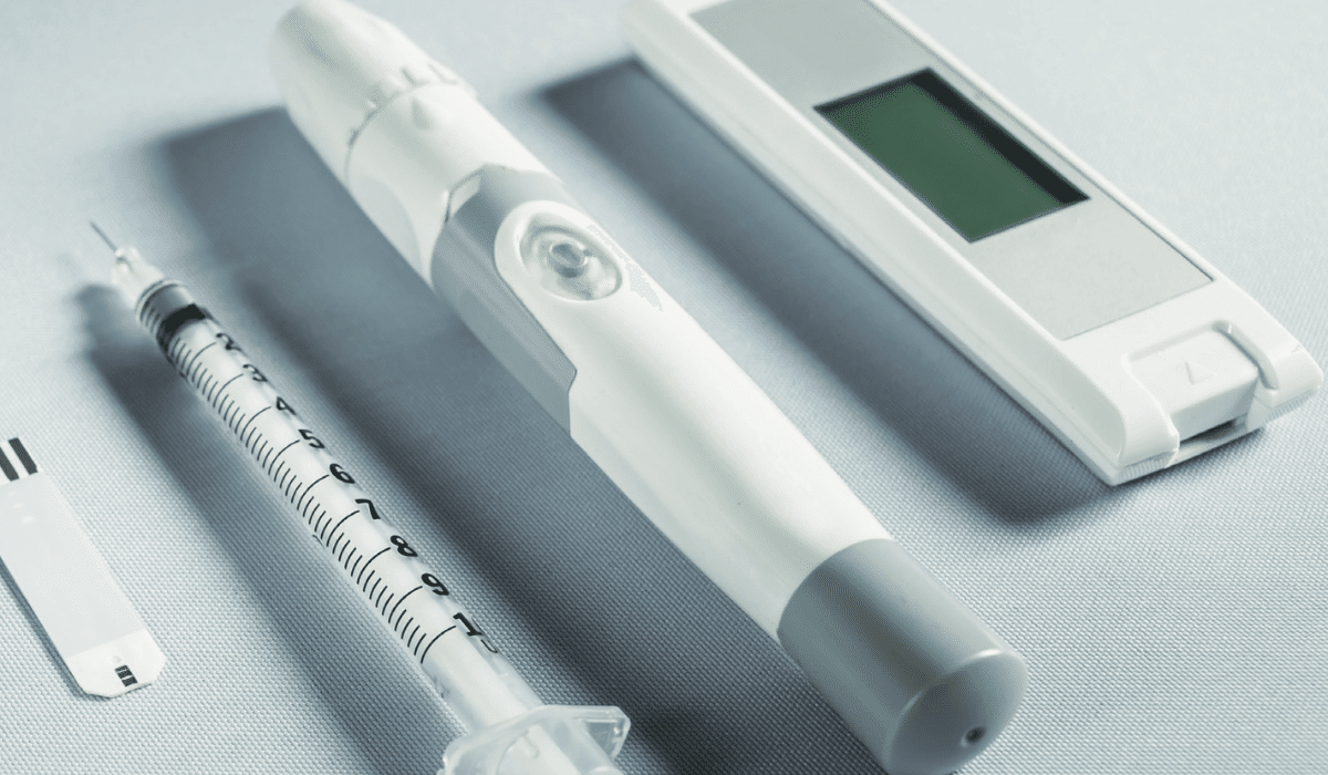 Gros plan sur un dispositif médical connecté — stylo injecteur, seringue et capteur numérique — illustrant les exigences de conformité et de certification des dispositifs médicaux intégrant l’intelligence artificielle en 2025.