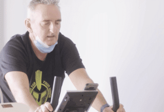 Patient en séance d’exercice sur vélo d’appartement dans le cadre d’un programme de téléréadaptation cardiaque.