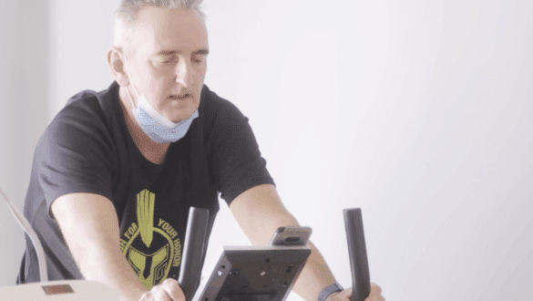 Patient en séance d’exercice sur vélo d’appartement dans le cadre d’un programme de téléréadaptation cardiaque.