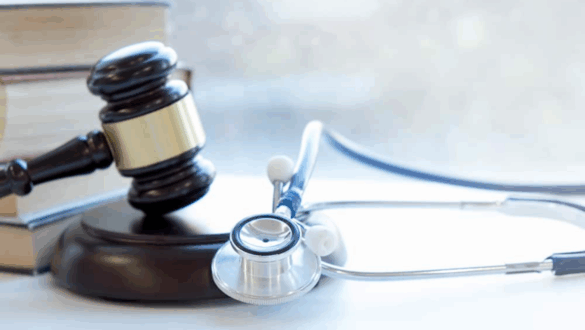 Marteau de justice et stéthoscope posés sur un bureau, symbolisant la réglementation en santé et les obligations légales des acteurs médicaux.