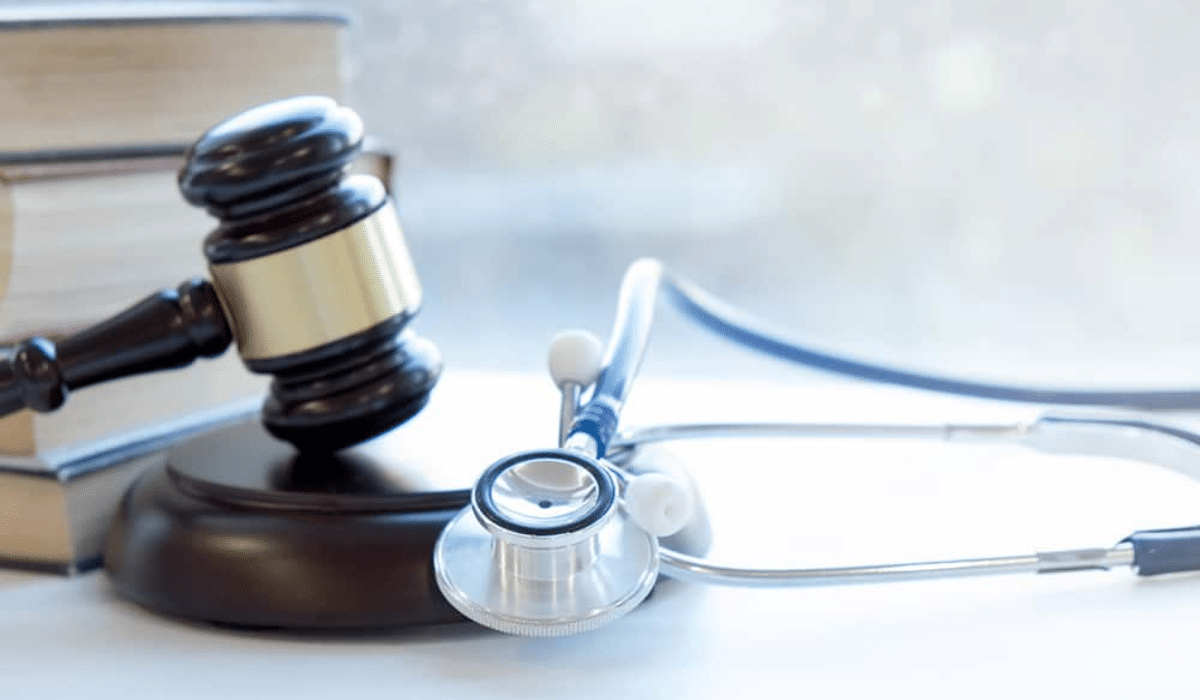 Marteau de justice et stéthoscope posés sur un bureau, symbolisant la réglementation en santé et les obligations légales des acteurs médicaux.